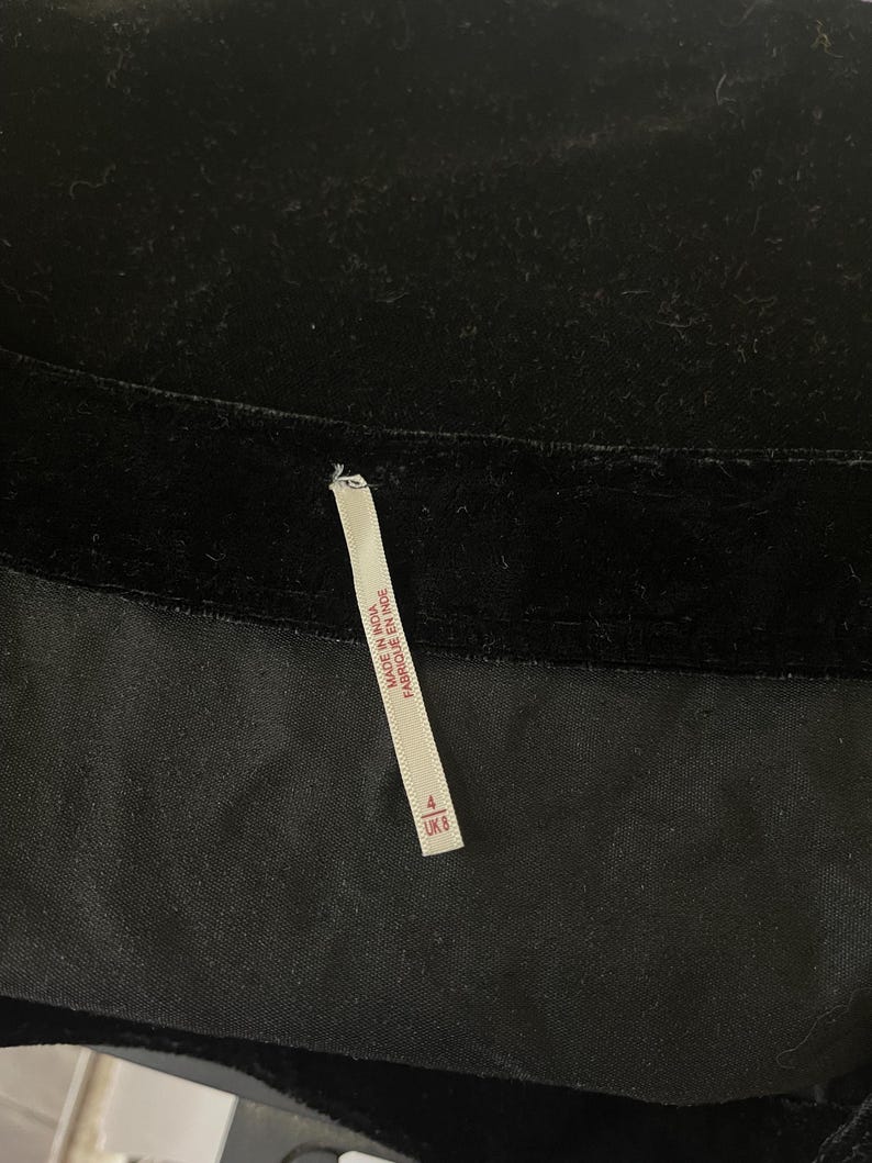 May include: Black velvet skirt with a white tag that reads "Made in India, Fabrique en Inde" and a size tag that reads "4 US 8 UK."