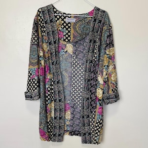 May include: A long, open-front cardigan with a patchwork design. The cardigan features floral, paisley, and geometric patterns in black, gold, pink, and blue. The label reads "Tracy Richards Sewing Pattern".