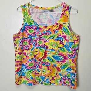 May include: A sleeveless tank top with a vibrant floral pattern in shades of pink, yellow, green, orange, and blue. The top has a scoop neckline and the brand name "Chicos" is visible.
