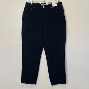 May include: Black denim jeans with a classic five-pocket design. The jeans have a high waist and a straight leg cut. The jeans are hanging on a hanger against a white background. The jeans have a button and zipper closure.