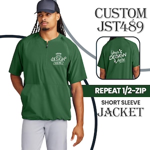 May include: A green short-sleeve jacket with a half-zip closure, front pocket, and the text "Your Design Here" on the front. The image also includes the text "CUSTOM JST489" and "REPEAT 1/2-ZIP SHORT SLEEVE JACKET".
