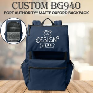 May include: Navy blue Port Authority Matte Oxford backpack with the text "CUSTOM BG940" and "YOUR DESIGN HERE". The backpack has a top handle, a front pocket, and side pockets. An inset shows the interior of the backpack.