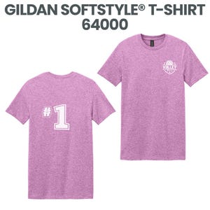 May include: Two heather purple Gildan Softstyle t-shirts. One shirt has a white "#1" graphic on the back. The other shirt has a small white "VOLLEY" logo on the front. The text "GILDAN SOFTSTYLE T-SHIRT 64000" is at the top.