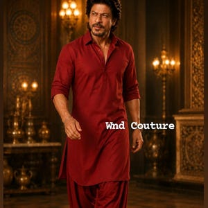 May include: A person wearing a maroon kurta and salwar suit. The outfit features a collared, button-down kurta with three-quarter sleeves and matching salwar pants. The text "Wnd Couture" is visible on the right side of the image.