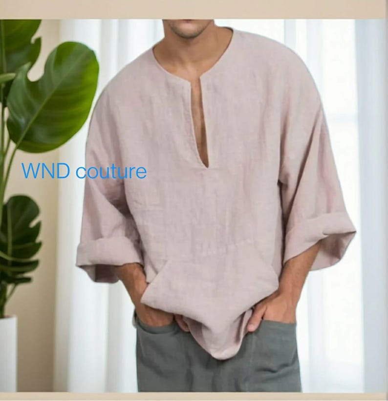 May include: A light pink linen shirt with a wide neckline and three-quarter sleeves. The shirt has a front pocket and the text "WND couture" is visible on the left side. The model is wearing gray pants.