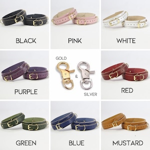 May include: A collection of leather wrist cuffs in various colors, including black, pink, white, purple, red, green, blue, and mustard. Each cuff features a gold-colored buckle and hardware. The image also shows gold and silver-colored clasps.