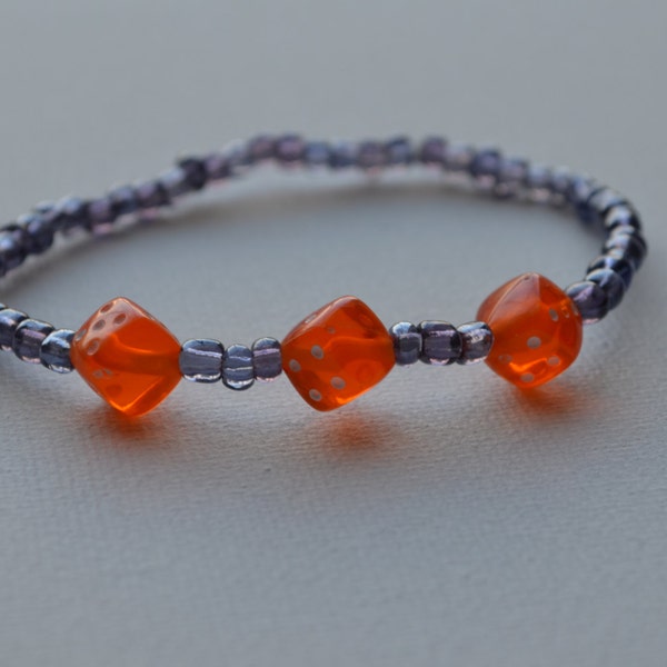 Bunco bracelet, purple glass seed beads with 3 orange dice, stretch bracelet