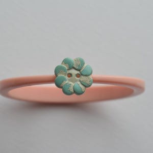 Pink vintage bangle bracelet with turquoise and cream flower vintage button