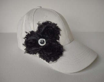 White baseball cap with black flowers and buttons