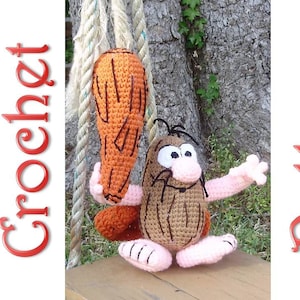 Könnte beinhalten: Häkel-Amigurumi-Spielzeug eines Cartoon-Höhlenmenschen mit einem Knüppel. Der Höhlenmensch ist braun mit schwarzen Haaren und einer rosa Nase. Der Knüppel ist orange und braun.