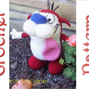 Puede incluir: Juguete de peluche tejido a crochet del personaje de dibujos animados Stimpy del programa Ren & Stimpy. Stimpy es blanco con zapatos rojos y una lengua rosa. Tiene ojos azules y una nariz roja.