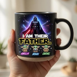 May include: Black ceramic mug featuring Darth Vader and the text "I AM THEIR FATHER." Below the text are three Grogu characters and the names Amelia, Noah, and Lucas. The mug has a black handle and a tan base.