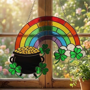 May include: Stained glass rainbow with a pot of gold, shamrocks, and clouds hanging in a window. The rainbow features vibrant colors, and the pot is filled with gold coins. A small potted plant sits on the windowsill.