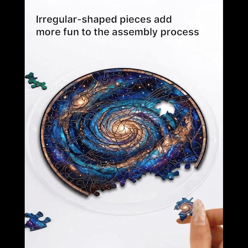 K&ouml;nnte beinhalten: Ein teilweise zusammengesetztes Holzpuzzle mit einem Galaxiedesign in Blau-, Gold- und Braunt&ouml;nen. Das Puzzle ist kreisf&ouml;rmig und hat unregelm&auml;&szlig;ig geformte Teile. Der Text lautet: "Unregelm&auml;&szlig;ig geformte Teile machen den Zusammenbau noch unterhaltsamer."
