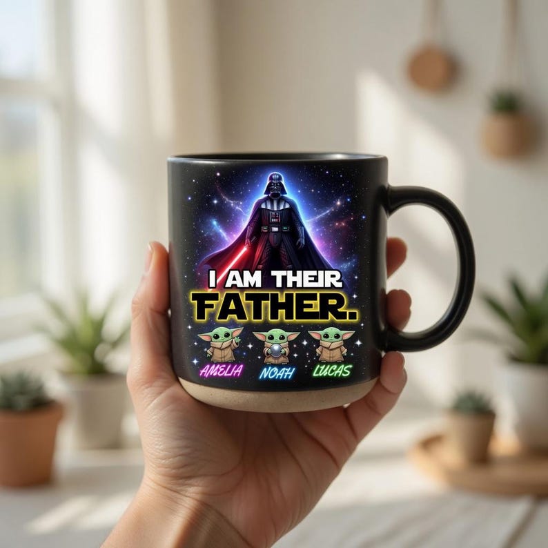 May include: Black ceramic mug featuring Darth Vader and the text "I AM THEIR FATHER." Below the text are three Grogu characters and the names Amelia, Noah, and Lucas. The mug has a black handle and a tan base.