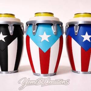 Könnte beinhalten: Drei dekorative Conga-Trommeln mit dem Design der puerto-ricanischen Flagge. Die Trommeln sind in Schwarz, Blau und Rot mit weißen Streifen und Sternen bemalt. Jede Trommel hat einen gelben Deckel und silberne Beschläge.