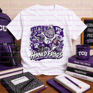 May include: A white short-sleeve t-shirt featuring a graphic of a TCU Horned Frogs mascot holding a football, wearing a jersey with the number 1, and surrounded by a purple helmet, a flag, and the text TCU HORNED FROGS in purple and white.