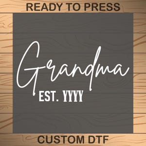 May include: A gray wood sign with white text that reads "Grandma Est. YYYY" with the words "Ready to Press" and "Custom DTF" at the top and bottom of the sign.