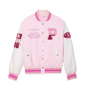 Puede incluir: Chaqueta universitaria rosa con mangas blancas, con un gran parche "P" rosa y el texto "The 5 Rules of Pink". La chaqueta tiene una parte delantera abotonada, puños acanalados y un cuello y dobladillo a rayas rosas y blancas.