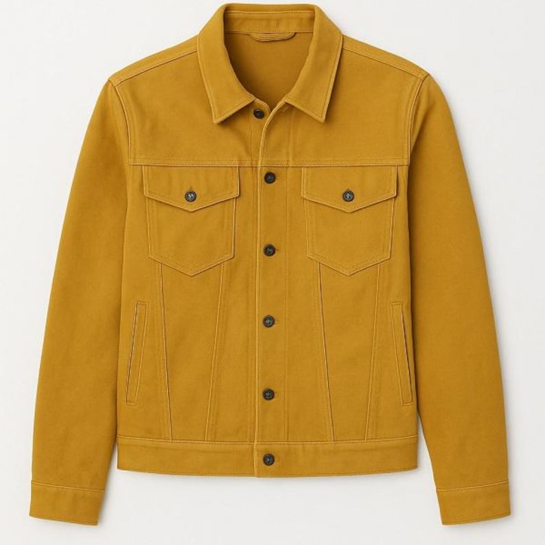 Puede incluir: Chaqueta vaquera color mostaza con un dise&ntilde;o cl&aacute;sico. Cuenta con cuello, dos bolsillos en el pecho y dos bolsillos laterales. La chaqueta tiene botones negros en la parte delantera y en los bolsillos. Una opci&oacute;n de abrigo elegante y vers&aacute;til.