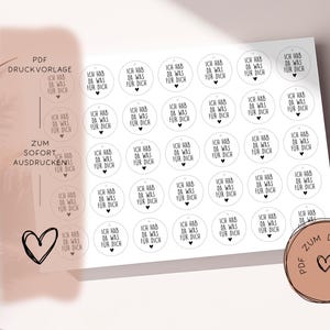 May include: Sheet of white stickers with black text and a heart design. Each sticker reads "Ich hab da was für dich" (I have something for you). Includes a PDF download option.