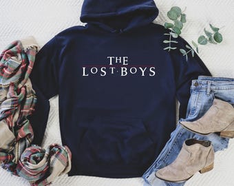 May include: A navy blue hoodie with a white graphic that says "THE LOST BOYS" in a red line.