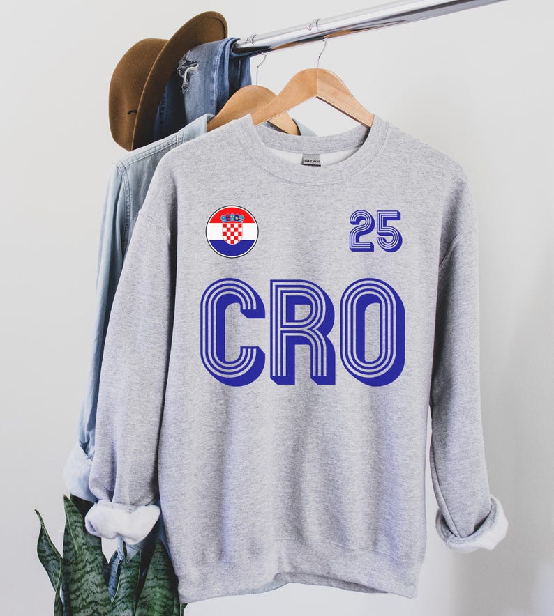 May include: Gray sweatshirt with a blue and white Croatian flag patch, the number 25, and the word "CRO" in a retro font.