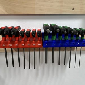 May include: A set of T-handle hex wrenches in a red and blue holder. The red holder has wrenches labeled with fractional inch sizes, while the blue holder has wrenches labeled with metric sizes. The wrenches have black shafts and red or green handles.