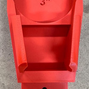 May include: A bright red, 3D-printed adjustable bracket with a black knob. The bracket has a 3-inch marking and a slot for adjustment. The design includes a base, a central support, and side supports.
