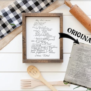 May include: A framed handwritten recipe for "My Dad's Sauce" on a white background. The recipe includes ingredients like ground meat, banana peppers, crushed tomatoes, and green peppers. The recipe is framed in a rustic wooden frame.