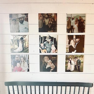 May include: A white wall with nine framed photographs of different people and families. The photos are arranged in a grid pattern.