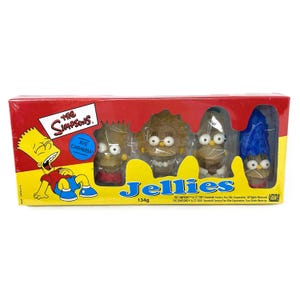 Może przedstawiać: Opakowanie żelków "Simpsonowie" z Bartem, Lisą, Marge i innymi postaciami. Pudełko jest czerwono-żółte, z logo serialu i napisami "Jellies" i "Aye Caramba". Opakowanie waży 134g.