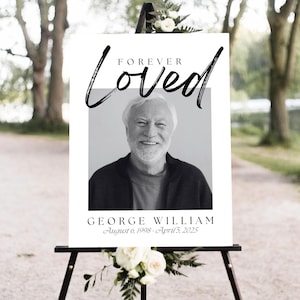 Peut inclure: Panneau commémoratif avec l'inscription "Forever Loved" en écriture élégante au-dessus d'une photo en noir et blanc d'un homme souriant. Le panneau comprend le nom "GEORGE WILLIAM" et les dates "6 août 1998 - 5 avril 2025".