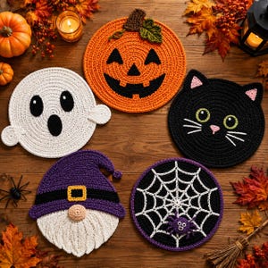 Könnte beinhalten: Fünf runde Häkeluntersetzer mit Halloween-Motiven: ein orangefarbener Kürbis, ein weißes Gespenst, ein schwarzes Katzengesicht, ein violetter Gnom mit Bart und Hut sowie ein schwarzer Kreis mit weißem Spinnennetz und einer kleinen lila Spinne.