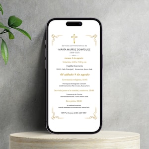 Op de afbeelding: Een smartphone toont een aankondiging van een herdenkingsdienst. De tekst bevat de naam María Muñoz Domínguez, de data 1959-2025 en details van de dienst. Het ontwerp heeft een gouden kruis en decoratieve randen.