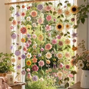 May include: A window curtain made of multiple vertical strands of crocheted flowers and green leaves in various shades of pink, yellow, purple, and white. The floral strands are suspended from a horizontal wooden rod across the window frame.