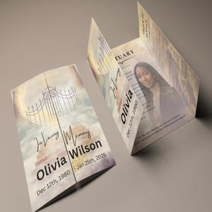 May include: A tri-fold memorial card with a celestial design. The front features the text "In Loving Memory" and the name "Olivia Wilson" with dates. The inside includes a photo and the text "Obituary". The card is in shades of beige and gold.
