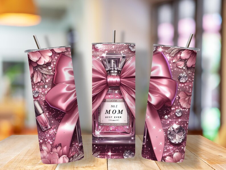 May include: A pink tumbler with a decorative design. The design includes a perfume bottle with a large bow, floral accents, and the text "No. 1 MOM BEST EVER". The tumbler has a straw.