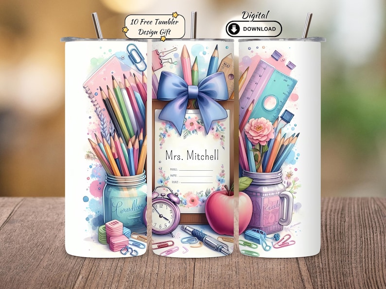 May include: A white tumbler featuring a watercolor design with school-themed elements. The design includes pencils, a ruler, a pink apple, and a blue bow. The tumbler has the text "Mrs. Mitchell" and "10 Free Tumbler Design Gift".