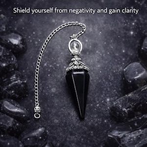 May include: A black obsidian pendulum with a silver chain and decorative cap. The image includes text that reads "Obsidian Pendulum" and "Shield yourself from negativity and gain clarity."