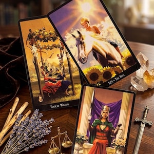 May include: Three tarot cards are displayed, featuring detailed illustrations. One card shows a figure on a white horse with sunflowers, labeled "XIX The Sun." Another depicts figures with wands, labeled "Four of Wands." The third card shows a figure holding a sword and scales, labeled "XI Justice."