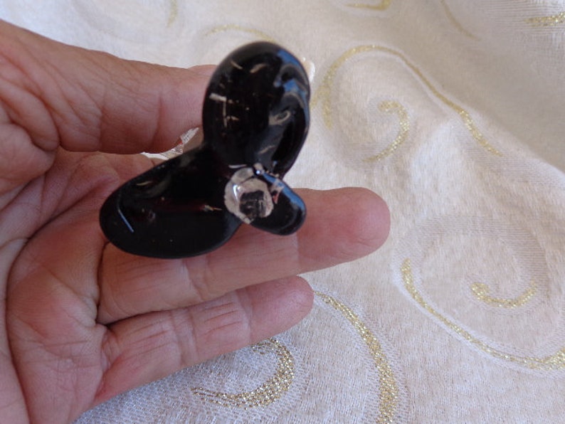 May include: A black plastic butterfly-shaped hair clip with a shiny silver accent.
