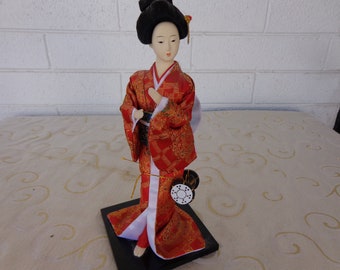 GEISHA IN RED - 12" Geisha  Doll  - Geisha Art Doll with Drum at by her knees  - Dressed in Red Silk Brocade and Wearing Turquoise/Green Obi