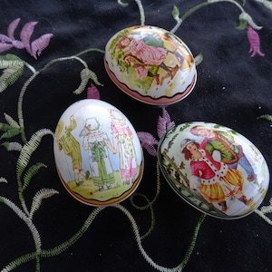 Three Vintage  Eggs -  Aluminum.  One skater scene, One Kite Scene   One Hobby Horse scene