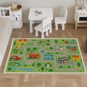 Può includere: Un tappeto gioco per bambini con un design a mappa della città. Il tappeto presenta strade, edifici come una scuola, un negozio e una stazione di servizio e un piccolo lago. Il design include un elicottero, un autobus e un treno. Il tappeto è su un pavimento in legno.