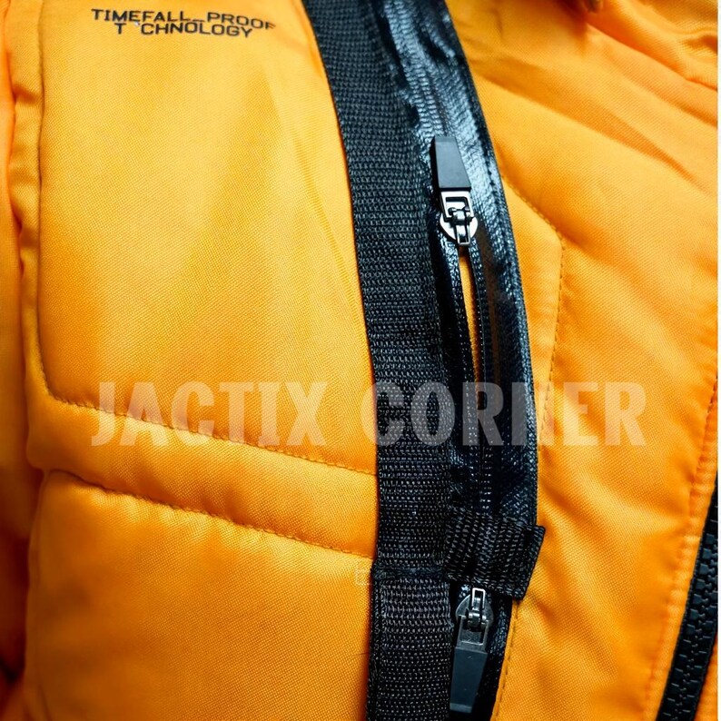 May include: Close-up of a bright orange jacket with black zippers and trim. The jacket has a quilted pattern and the text "TIMEFALL PROOF TECHNOLOGY" is printed at the top. The text "JACTIX CORNER" is printed at the bottom.