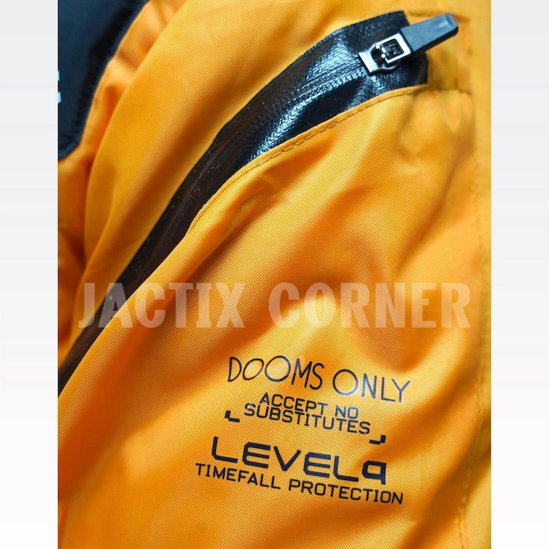 May include: Close-up of a bright orange jacket with a black zipper and trim. The text "DOOMS ONLY ACCEPT NO SUBSTITUTES" and "LEVEL4 TIMEFALL PROTECTION" is printed on the jacket. The brand name "JACTIX CORNER" is also visible.
