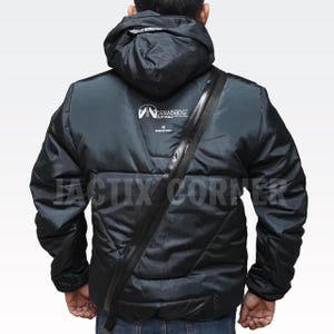 May include: Black puffer jacket with a hood and a diagonal zipper across the chest. The jacket has the "DRAWBRIDGE" logo on the back and the text "FACTIX CORNER" at the bottom. The jacket is worn by a person.