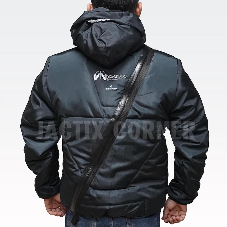 May include: Black puffer jacket with a hood and a diagonal zipper across the chest. The jacket has the "DRAWBRIDGE" logo on the back and the text "FACTIX CORNER" at the bottom. The jacket is worn by a person.