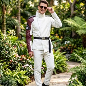May include: A white jacket with a high collar and a maroon right sleeve featuring a circular emblem, paired with matching white trousers and a black belt with a silver buckle. The jacket has an asymmetrical front closure and structured shoulders.